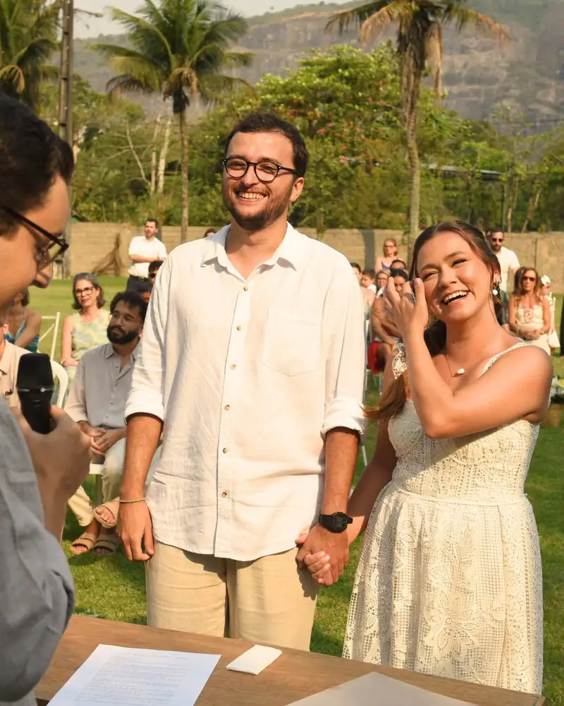 Noivos sorrindo durante a cerimônia ao ar livre