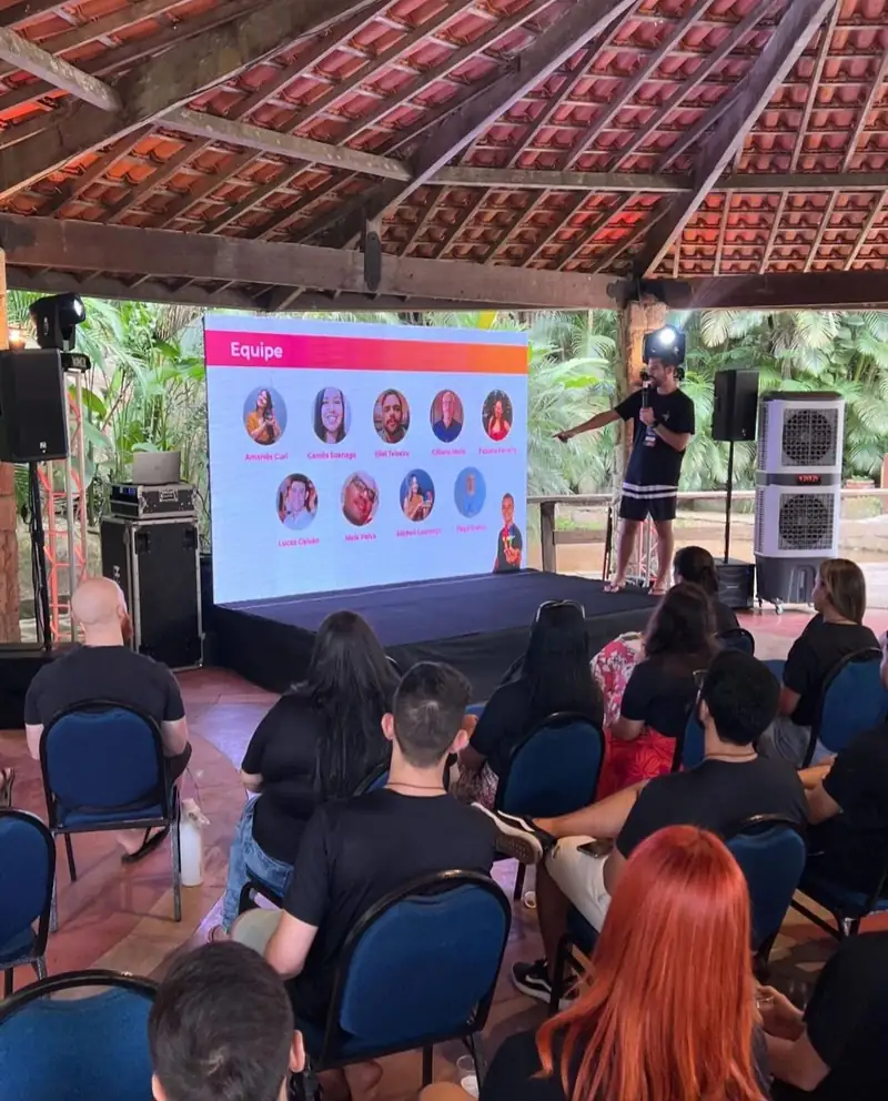 Apresentação para a equipe em salão do sítio, com telão