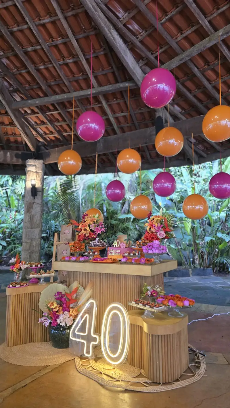 Mesa de doces com letreiro neon de 40 anos e flores