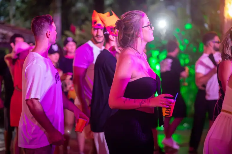 Pista de dança cheia à noite sob luzes coloridas