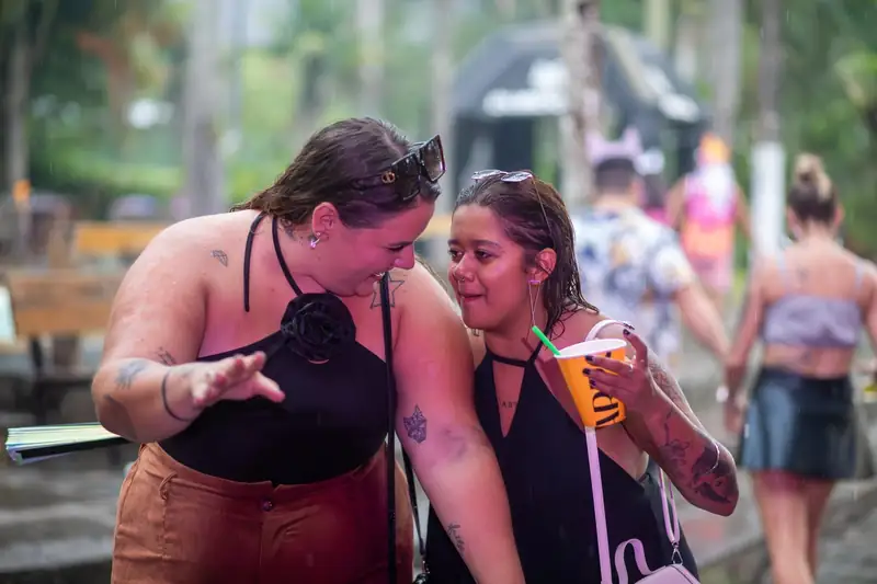 Duas amigas conversando de copo na mão