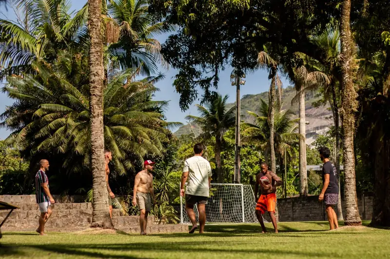 Pessoas jogando bola no campo gramado do sítio
