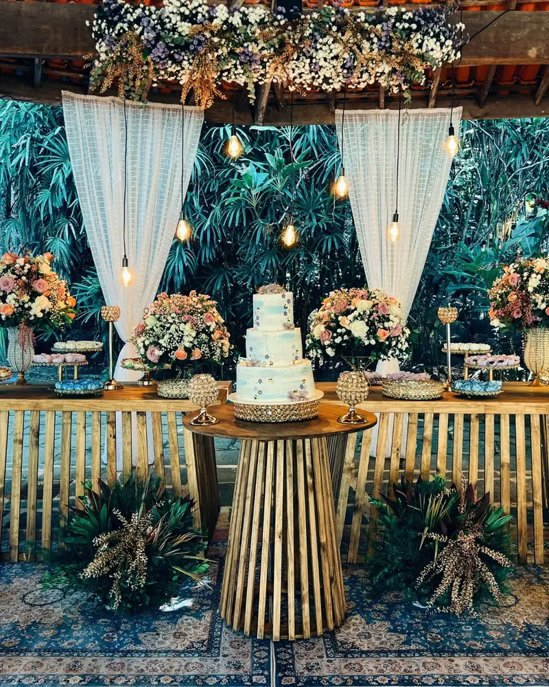 Mesa de bolo decorada com flores e cortinas
